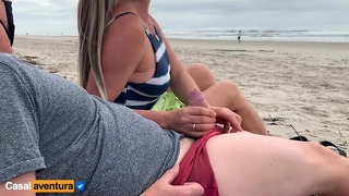 Mor og far nyter kvikk på den offentlige stranden