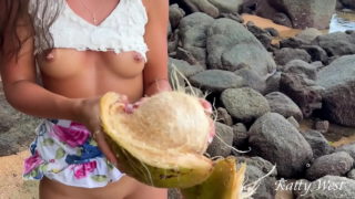 Naken jente fant en kokosnøtt på en offentlig strand og helte juicen over kroppen hennes