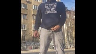 Hetero Bulgaarse man pist op zijn trainingsbroek in een openbare straat
